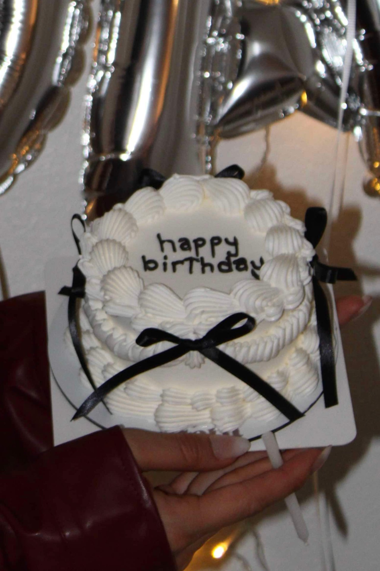 Custom white birthday cake with black ribbon